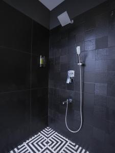 a black bathroom with a shower with a phone at K Hotels by SYN in Bangalore +17 photos