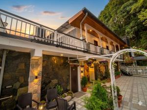 a house with a balcony and a patio at Hotel Oakland Landour in Mussoorie