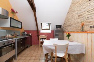 a kitchen and dining room with a table and chairs at Gîte Nautilus in Elven +12 photos
