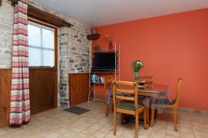 a dining room with a table and a television at Gîte Peigne De Vénus in Elven