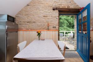 a kitchen with a table and a refrigerator and a door at Gîte Nautilus in Elven