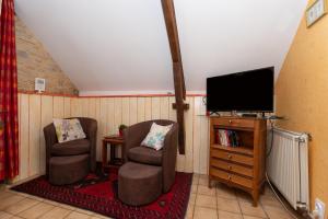 a living room with two chairs and a flat screen tv at Gîte Nautilus in Elven