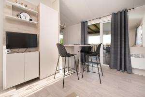 a living room with a table and chairs and a tv at La Brisse d'Erdeven in Erdeven