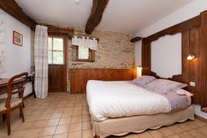 a bedroom with a bed and a desk in a room at Gîte Peigne De Vénus in Elven
