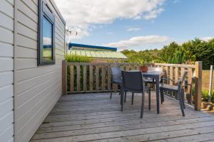 a wooden deck with a table and chairs on it at La Brisse d'Erdeven in Erdeven