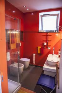 a red bathroom with a toilet and a sink at The Loft Via Torricella in Ravello