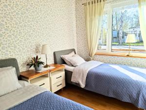 a bedroom with two beds and a window at Meie Hiiumaa majutus Kärdlas in Kärdla