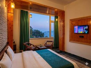 a bedroom with a bed and a large window at Hotel Oakland Landour in Mussoorie