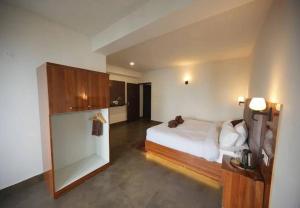 a bedroom with a white bed and a room with at Urbane Haauz in Pelling