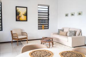 a living room with a white couch and chairs at Bantaskine Apartments in Paramaribo