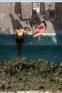 a man and a woman swimming in a swimming pool at Paros Cape Suites in Naousa