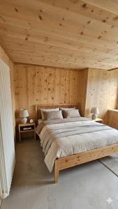 a bedroom with a large bed in a wooden wall at Rifugio Ghiacciaio dei Forni in Valfurva