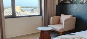 a hotel room with a chair and a window at White Panda hotels Shree Radhe in Dwarka