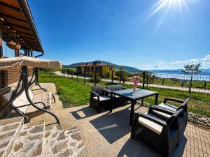a patio with a table and chairs and the ocean at ng royal in Rakitovo