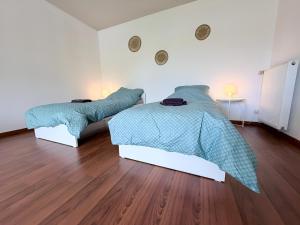 a bedroom with two beds and a wooden floor at Über den Dächern von Borghorst - direktes Zentrum in Steinfurt