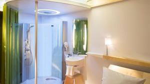 a bathroom with a sink and a shower at Nomad Hotel le Havre Centre Gare in Le Havre