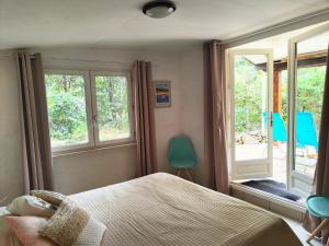 a bedroom with a bed and two windows at Les 4 mousquetaires in Méjannes-le-Clap +61 photos