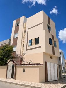 a tall white building with a garage at La maison douce Bizerte in Bizerte