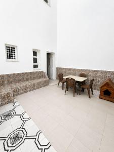 a patio with a table and chairs and a brick wall at La maison douce Bizerte in Bizerte