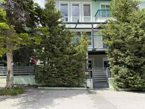 a building with a balcony and trees in front of it at Elato apartment in Florina