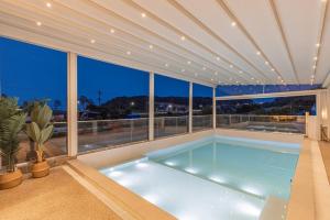 a swimming pool in a house with a large window at Private Yangyang Dockchae Pool Villa in Yangyang