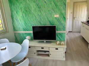 a living room with a television on a table with chairs at De huismus in Sleen