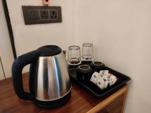 a tea kettle on a wooden table with a tray at Hotel Oakland Landour in Mussoorie
