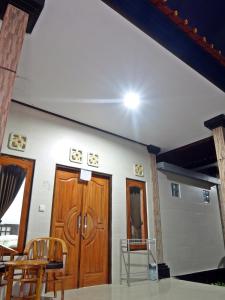 um quarto com duas portas e cadeiras de madeira em Pondok Wisata Widi em Nusa Lembongan