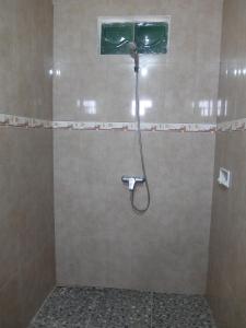 a shower with a shower head in a bathroom at Pondok Wisata Widi in Nusa Lembongan