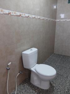een badkamer met een wit toilet in een kamer bij Pondok Wisata Widi in Nusa Lembongan