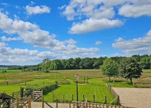 a field with a fence and a blue sky with clouds at Hampshire Hills in Bighton