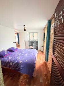 a bedroom with a blue bed in a room at Charmant gite en pierre in Gratot