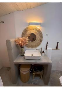 a bathroom with a sink and a mirror on a counter at Casa Tia Anica I in Monsaraz