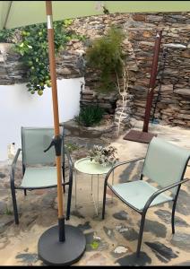 two chairs and a table with an umbrella at Casa Tia Anica I in Monsaraz