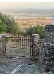 a gate in a stone wall with a view at Casa Tia Anica I in Monsaraz +5 photos