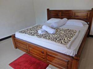 a bed with a wooden frame with two towels on it at Pondok Wisata Widi in Nusa Lembongan