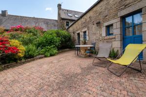 a patio with two chairs and a table at Gîte Peigne De Vénus in Elven