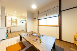 a living room with a table and a kitchen at Kamenoya, 羽田空港&ディズニー直通バス,2トイレ,亀有駅徒歩7分 in Tokyo