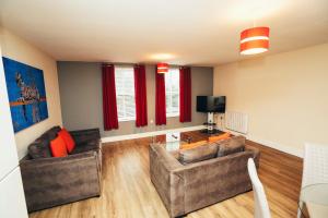 a living room with two couches and a tv at Dalby House in Derby