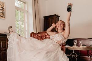 a woman in a wedding dress holding a camera at Felsenmühle Neuleiningen in Neuleiningen