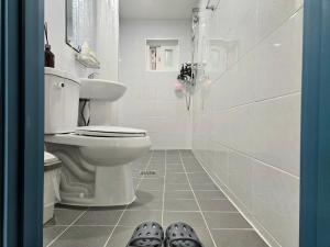 a bathroom with a toilet and two pairs of shoes at 행궁동-House1 in Suwon +38 photos