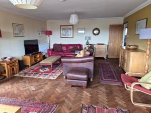 a living room with a couch and chairs and a tv at Lyndale in Tobermory