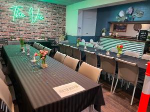 a dining room with tables and chairs and a neon sign at The Victoria Hotel in Collie