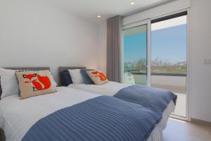 a bedroom with two beds and a large window at Designer Villa with BBQ & Heated Pool on Santa Rosalia Lake Resort in Torre-Pacheco +45 photos