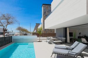 a patio with a swimming pool and lounge chairs at Designer Villa with BBQ & Heated Pool on Santa Rosalia Lake Resort in Torre-Pacheco