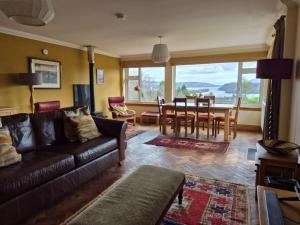 a living room with a couch and a dining room at Lyndale in Tobermory