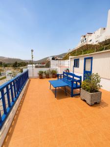 a patio with a blue bench on a balcony at Casa de Hollanda in Sidi Ifni +11 photos