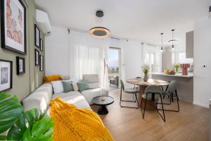 a living room with a white couch and a table at Lejla Garden Apartment in Podstrana