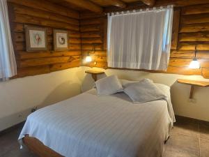 a bedroom with a bed in a log cabin at Casa cuidamos in Mar de las Pampas