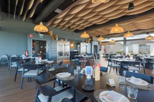a dining room with tables and chairs and chandeliers at Designer Villa with BBQ & Heated Pool on Santa Rosalia Lake Resort in Torre-Pacheco